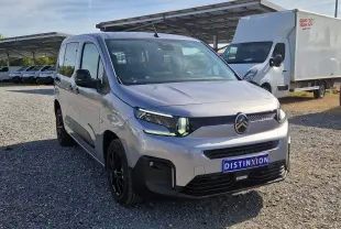 Vue 3/4 avant gauche d'un Citroën Berlingo gris Artense avec calandre noire et jantes noires sur un parking extérieur.
