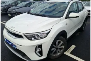 KIA Stonic blanc vue 3/4 avant droit, SUV compact avec toit noir et jantes alliage, stationné sur parking.