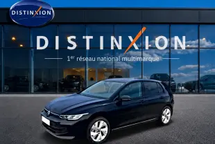 Volkswagen Golf noir vue 3/4 avant droit, avec jantes alu 17 pouces, devant une vitrine Distinxion.