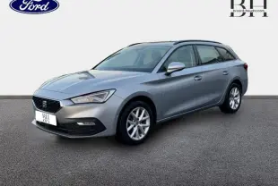 SEAT LEON ST gris urbain métal vue 3/4 avant droit, jantes alu et barres de toit visibles sur fond neutre.