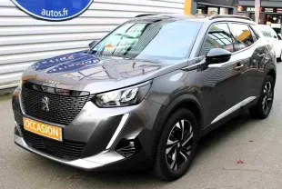 Peugeot 2008 gris platinium en 3/4 avant droit, avec jantes noires et calandre imposante, stationné en extérieur.