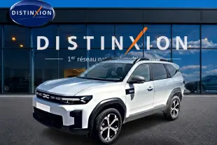 Dacia Bigster blanc en vue 3/4 avant droit, avec barres de toit et jantes alliage distinctives.
