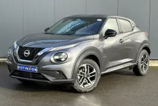 Nissan Juke gris foncé en 3/4 avant droit, avec jantes alliage 17'' et calandre noire distinctive.
