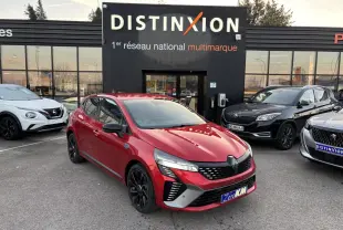 Renault Clio V rouge foncé vue 3/4 avant, jantes noires et détails Alpine devant concession Distinxion.