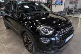 Fiat 500X noir cinéma vue 3/4 avant droit en showroom, mettant en valeur ses phares LED et jantes bi-ton.