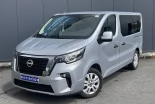 Nissan Primastar gris Highland vue 3/4 avant droit, hayon arrière vitré et vitres arrière surteintées visibles.