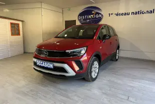 Vue 3/4 avant d’un Opel Crossland rouge 2022 en intérieur, avec calandre noire et plaque « OCCASION » visible.