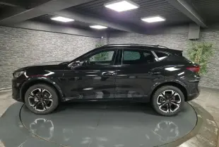 Profil côté gauche du CUPRA Formentor noir avec jantes alliage 18'' usinées dans un showroom intérieur.