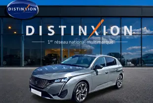 Peugeot 308 gris vue 3/4 avant droit, avec jantes alliage et calandre distinctive, devant showroom Distinxion.