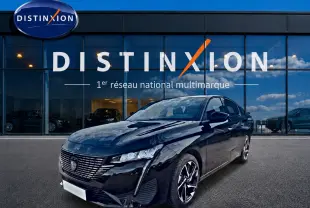 Peugeot 308 noire vue en 3/4 avant droit, avec calandre distinctive et jantes alliage modernes, devant showroom Distinxion.