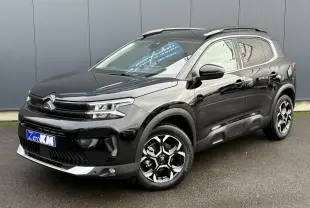 Vue 3/4 avant droite d'un Citroën C5 Aircross noir Perla avec jantes diamantées bi-ton et barres de toit noires.