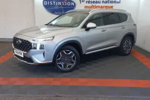 Hyundai Santa Fe gris clair en 3/4 avant droit, avec calandre noire et jantes alliage distinctives.