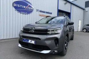Vue 3/4 avant droit d'un Citroën C5 Aircross 2025 gris platinium métallisé avec calandre noire et jantes noires.