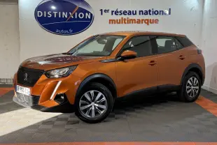 Peugeot 2008 orange vue 3/4 avant droit en intérieur, avec calandre noire et jantes bicolores.