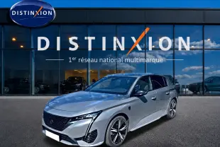 Peugeot 308 1.2 hybrid gris vue 3/4 avant droit, avec jantes alu et calandre noire distinctive.