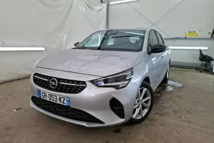 Opel Corsa gris clair vue 3/4 avant droit, avec jantes alliage 16'' et rétroviseurs noirs dans un garage.