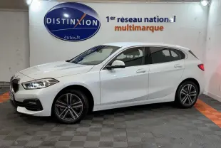 BMW Série 1 116i Business Design blanche vue de profil côté gauche dans un showroom avec logo Distinxion en arrière-plan