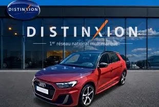Audi A1 Sportback rouge et noir vue 3/4 avant droit devant un showroom Distinxion.