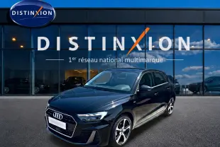 Audi A1 Sportback noir vue 3/4 avant droit, avec jantes alu et calandre hexagonale S line devant un showroom Distinxion.