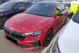 Vue 3/4 avant d'une Skoda Scala TSI 116 Monte-Carlo rouge Velvet avec jantes noires et toit panoramique visible.
