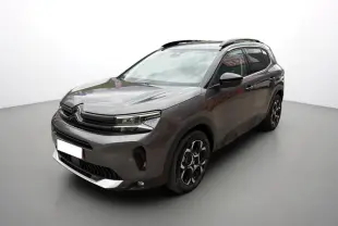 Citroën C5 Aircross gris platinium en 3/4 avant droit, avec barres de toit et jantes alu 18 pouces distinctives.