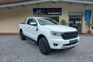Ford Ranger Super Cabine Limited blanc vu en 3/4 avant droit avec calandre noire et jantes noires sur gravier.