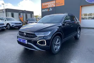 Volkswagen T-Roc noir nacré 2025 en 3/4 avant droit, avec feux LED et jantes alliage visibles sur parking.