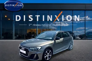 Audi A1 Sportback 30 TFSI gris chronos vue 3/4 avant droit avec jantes alu et toit noir devant showroom Distinxion.
