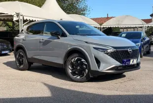 Nissan Qashqai e-Power gris clair en 3/4 avant droit, avec calandre noire et jantes noires distinctives.