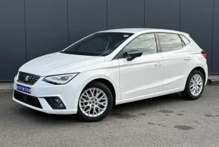 SEAT Ibiza TSI 115 Xcellence blanc vue 3/4 avant avec jantes alliage et rétroviseurs noirs sur fond urbain.