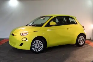 Vue de profil droit d'une FIAT 500 électrique jaune vif avec jantes argentées dans un studio.