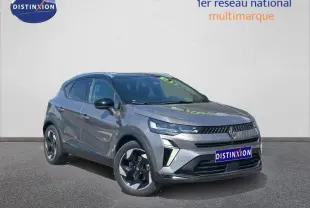 Renault Captur 1.6 E-Tech hybride 2025 en 3/4 avant, gris Cassiopée métallisé avec toit noir et jantes alu noires.