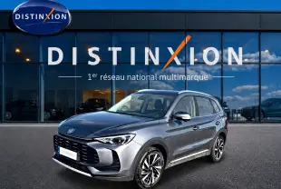 MG ZS 1.5 hybrid gris en 3/4 avant droit, avec calandre noire et jantes alliage 18 pouces visibles.