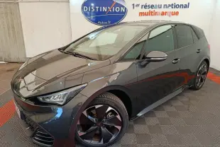 Vue 3/4 avant droit d'une CUPRA BORN gris foncé avec jantes noires et logo distinctif sur calandre.