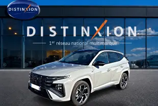 Hyundai Tucson 1.6 T-GDI hybride gris shadow en 3/4 avant droit, avec calandre noire et jantes alu distinctives.