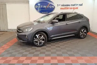 Vue de profil côté gauche du Volkswagen Taigo gris foncé 2023 avec jantes alliage et vitres teintées en showroom.