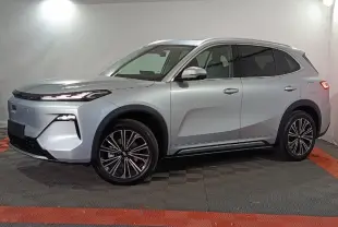 Vue de profil côté gauche d’un SUV Geely STARRAY gris clair avec jantes alliage et feux arrière allumés.
