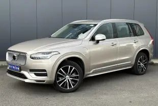 Volvo XC90 T8 hybride gris Dusk en 3/4 avant droit, avec jantes alliage noires et contour chromé des vitres.