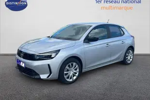 Opel Corsa gris 2025 vue 3/4 avant droit, avec calandre noire et jantes alliage, stationnée devant un mur clair.