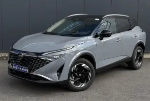 Nissan Qashqai gris Ceramic en 3/4 avant droit, avec calandre noire et jantes alliage noires distinctives.