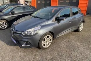 Renault Clio IV 1.5 dCi 90 Energy Business gris métallisé vue 3/4 avant côté droit, stationnée devant un bâtiment orange.