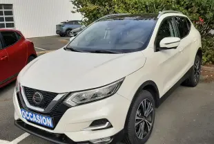 Nissan Qashqai blanc vue 3/4 avant droit, toit noir, jantes alliage bicolores, stationné en extérieur.