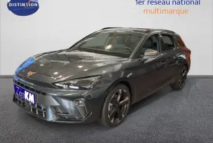 Vue 3/4 avant droite d'une CUPRA Leon ST gris métallisé avec jantes aluminium et barres de toit visibles.