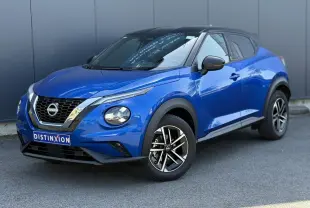 Vue 3/4 avant droite du Nissan Juke 2025 bleu magnétique avec toit noir et jantes alliage 17 pouces diamantées.