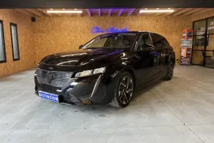 Peugeot 308 SW noire vue en 3/4 avant droit dans un showroom avec éclairage intérieur.