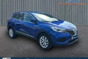 Renault Kadjar TCe 140 Business bleu foncé en 3/4 avant droit, avec jantes alliage et barres de toit visibles.