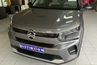 Citroën C3 turbo 100cv gris Mercury vue 3/4 avant en intérieur, avec calandre noire et phares LED distinctifs.