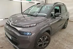 Citroën C3 Aircross gris foncé en 3/4 avant droit avec barres de toit noires et jantes 16 pouces.