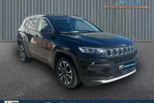 Jeep Compass noir en 3/4 avant droit, avec barres de toit et jantes 18 pouces visibles sur fond urbain.