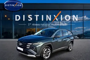 Hyundai Tucson 1.6 t-gdi 239 hybride vert en 3/4 avant droit devant un showroom Distinxion.